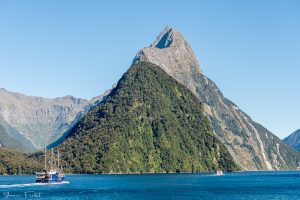 Boat cruising by Mitre Peak in Milford Sound, New Zealand