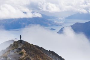 Walker overlooking lake Wanaka through the clouds